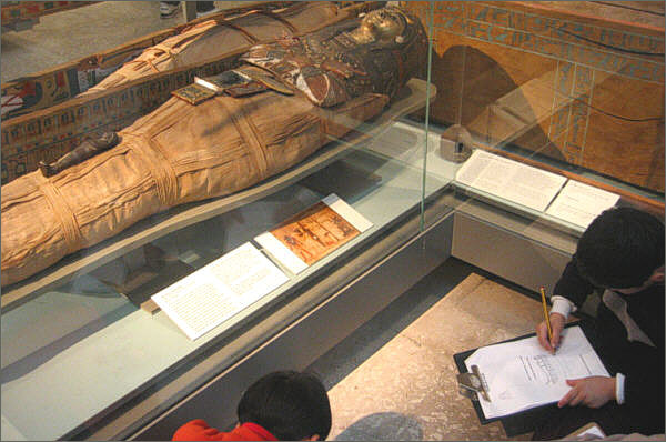 Schoolchildren copying notes by a mummy in the British Museum, picture by Francis Chin